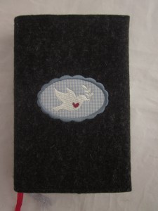 Taubenbutton blau auf dunklem Filz