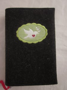 Taubenbutton grün auf dunklem Filz