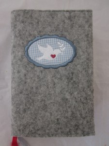 Taubenbutton blau auf hellem Filz